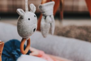 2nd baby must haves, baby laying under a wooden play gym